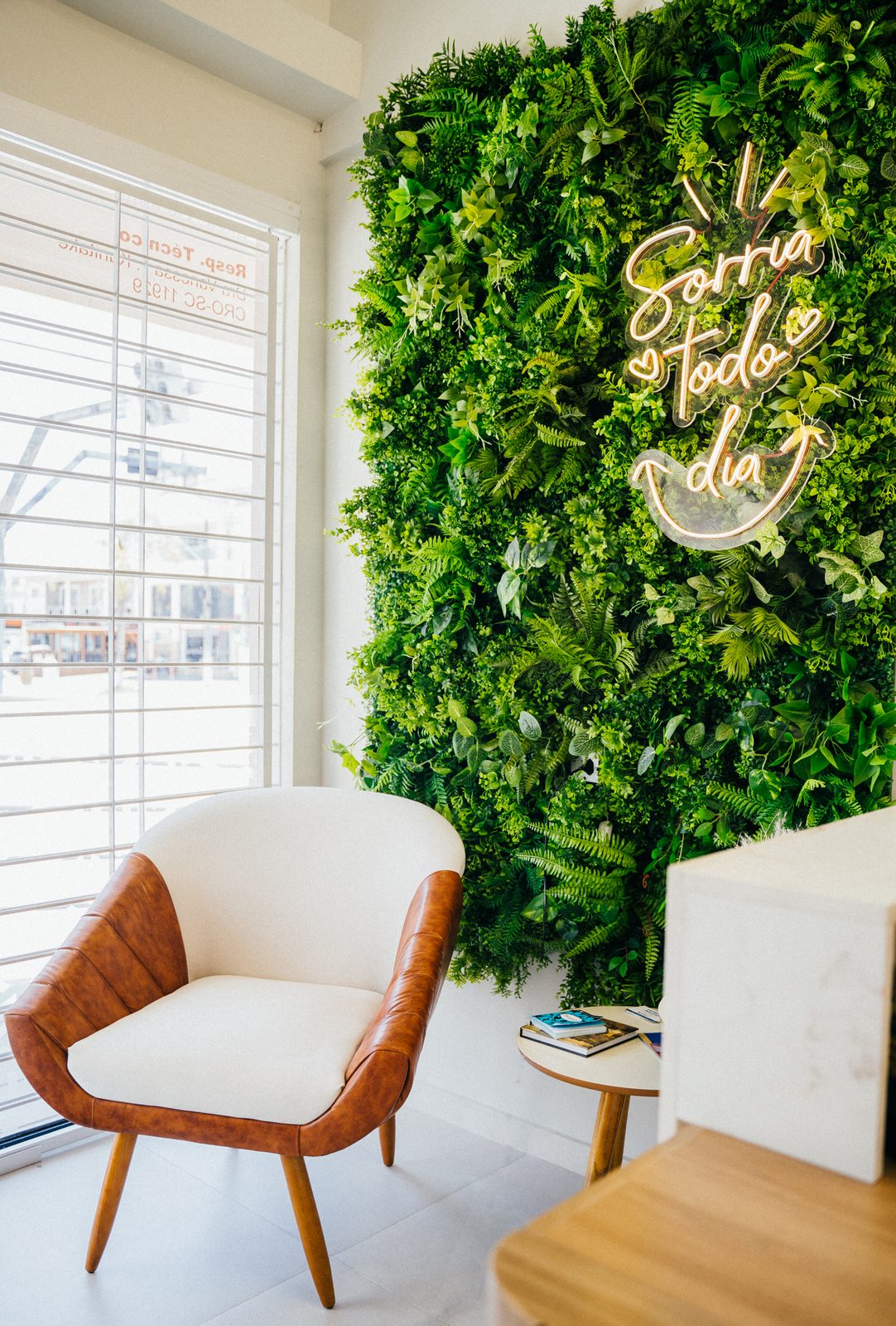 Lounge da COP com parede de plantas e letreiro Sorria todo dia